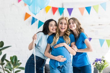 çok kültürlü arkadaş grubu balonlar ve hamile kadın bebek taraf kameraya bakarak gülen