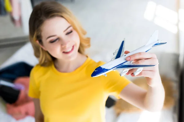 beautiful smiling young woman with airplane model