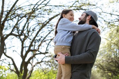 Baba holding kız parkta düşük açılı görünümü