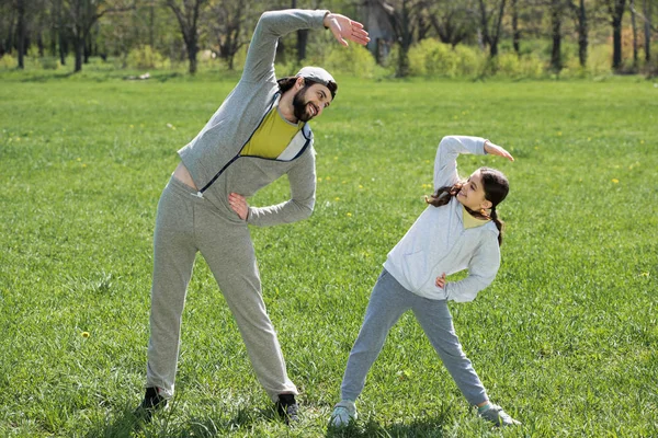 Usmívající Dcera Otec Dělá Fyzické Cvičení Louce Parku — Stock fotografie