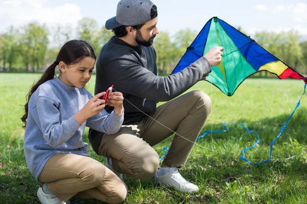 Vater Und Tochter Sitzen Mit Drachen Auf Wiese Park — Stockfoto