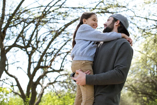 在公园的父亲抱女儿的低角度视图 — 图库照片