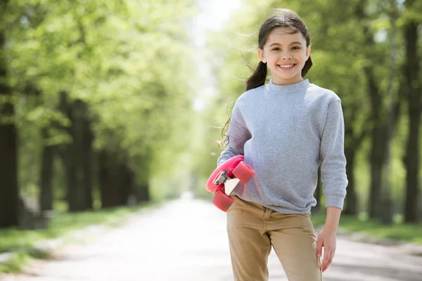 Petit Enfant Souriant Tenant Penny Conseil Dans Parc — Photo