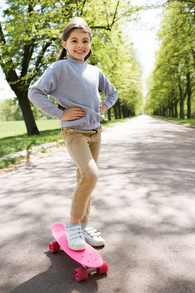 公園のパス上のスケート ボードと立っている笑顔の子 — ストック写真
