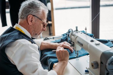 gri saç terzi Dikiş dikiş makinesi dikiş Atölyesi'nde bezle yan görünüm