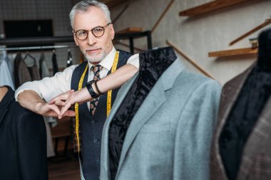 ceket Dikiş Atölyesi'nde manken üzerinde eğilerek teyp ölçme ile şık olgun terzi