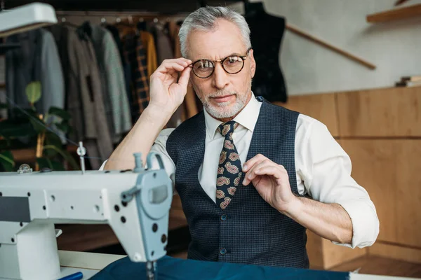 Senior Tailor Touching Glasses Looking Camera Sewing Workshop — Stock Photo, Image