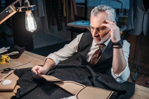 Thoughtful Mature Tailor Sitting Workplace Sewing Workshop Late Evening — Stock Photo, Image