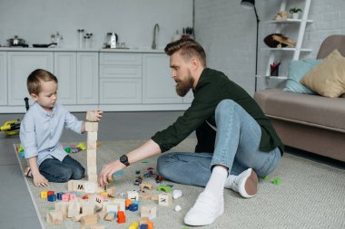 Baba ve oğul birlikte evde tahta bloklarla oynama