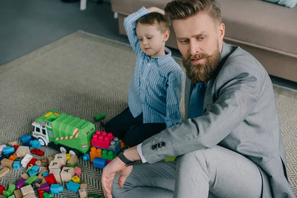 Selective Focus Pensive Businessman Suit Sitting Little Son Floor Home — Free Stock Photo