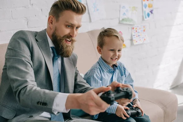 Επιχειρηματίας Και Μικρός Γιος Παίζοντας Βιντεοπαιχνίδια Μαζί Στο Σπίτι Εργασία — Φωτογραφία Αρχείου