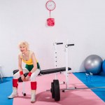 Senior deportivo mujer sentado y sonriendo a la cámara en el gimnasio