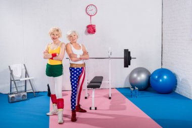 çapraz kolları ile ayakta ve spor salonunda kamera gülümseyen güzel üst düzey sportswomen 