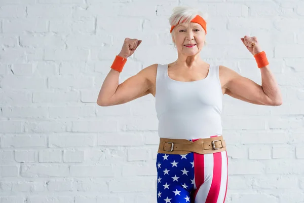 Glad Senior Idrottskvinna Visar Musklerna Och Ler Mot Kameran — Stockfoto