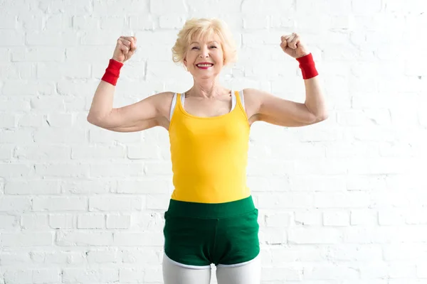 Feliz Mujer Mayor Ropa Deportiva Mostrando Los Músculos Sonriendo Cámara —  Fotos de Stock