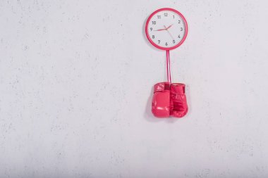 pembe boks eldivenleri duvar saati beyaz üzerinde asılı