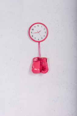 pembe boks eldivenleri pembe duvar saati beyaz üzerinde asılı