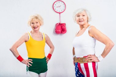 elle bel üzerinde duran ve kameraya gülümseyen mutlu üst düzey sportswomen