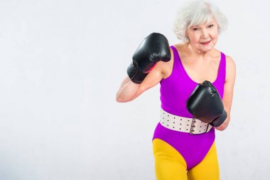 Sportif üst düzey Bayan boks ve gri izole kamera gülümseyen