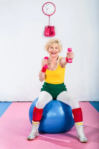 Glückliche Seniorin Sportkleidung Sitzt Auf Fitnessball Und Trainiert Mit Kurzhanteln — Stockfoto