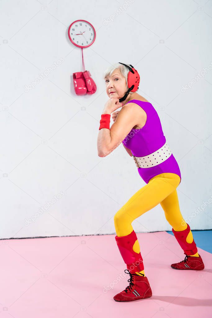 full length view of senior female boxer training and looking at camera