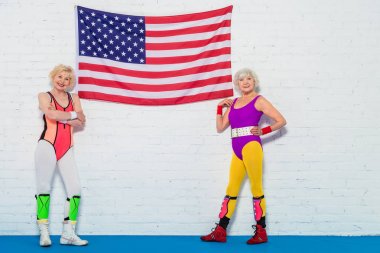 Amerikan bayrağı duran ve kameraya gülümseyen güzel üst düzey sportswomen  