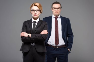 confident businesswoman with crossed arms and serious businessman, isolated on grey clipart