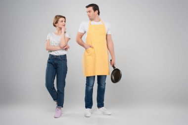 happy wife and husband in apron with frying pan, feminism concept, isolated on grey clipart
