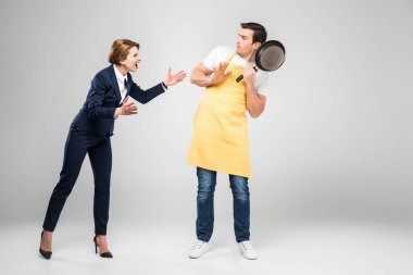 businesswoman yelling at scared husband with frying pan, feminism concept, isolated on grey clipart