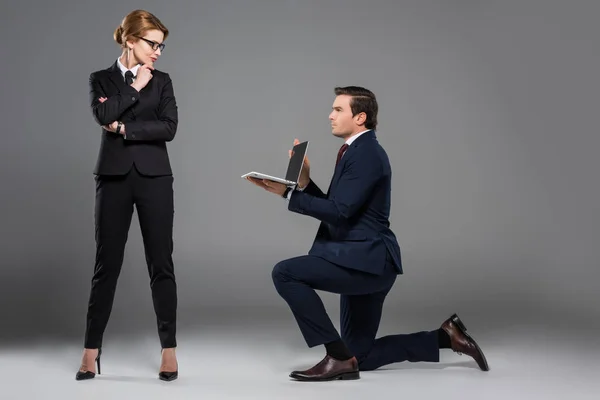 Businessman One Knee Holding Laptop Feminist Businesswoman Isolated Grey — Stock Photo, Image