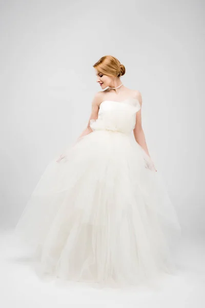 グレーに分離された白いウェディング ドレスでポーズ美しい花嫁 — ストック写真