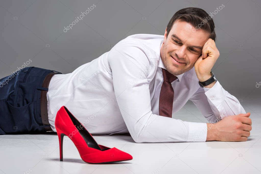 smiling businessman looking at female red hill, isolated on grey, feminism concept