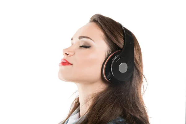 Mujer joven escuchando música en auriculares - foto de stock