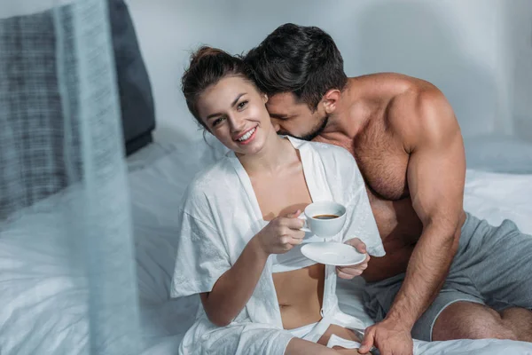 Giovane donna che prende il caffè a letto — Foto stock