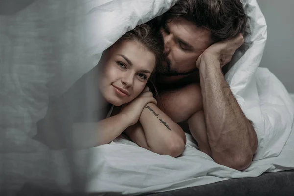 Happy couple under blanket — Stock Photo