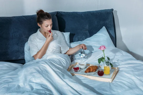 Woman having breakfast in bed — Stock Photo