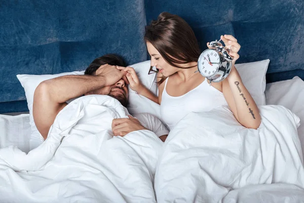 Couple waking up with alarm clock — Stock Photo