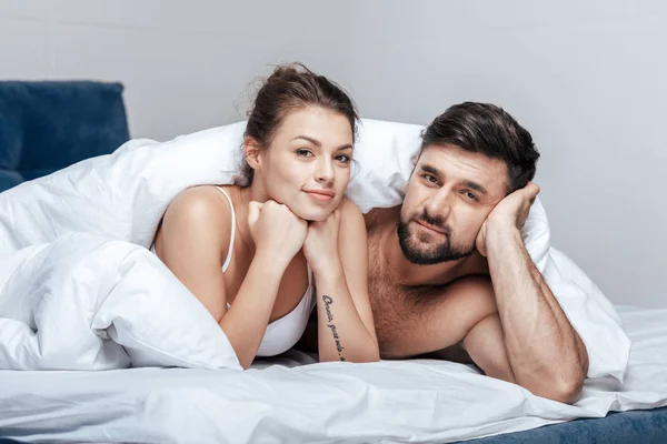 Heureux couple sous couverture — Photo de stock