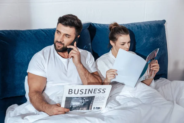 Pareja leyendo en la cama - foto de stock