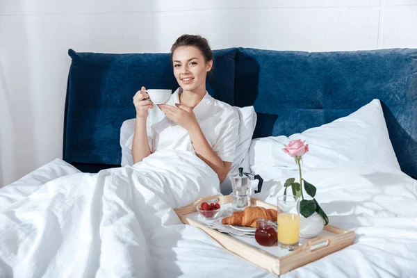 Жінка має каву в ліжку — стокове фото