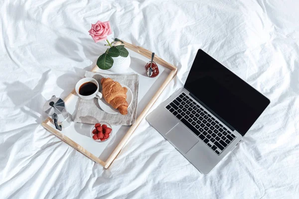 Plateau avec petit déjeuner et ordinateur portable — Photo de stock