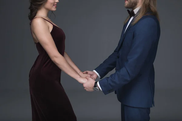 Sweethearts in formal wear holding hands — Stock Photo