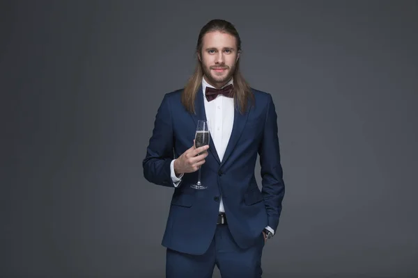 Mann im Smoking hält Glas mit Champagner — Stockfoto