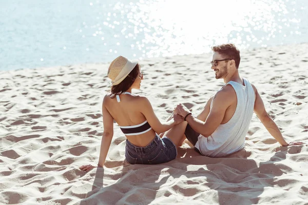 Feliz pareja joven en la playa - foto de stock