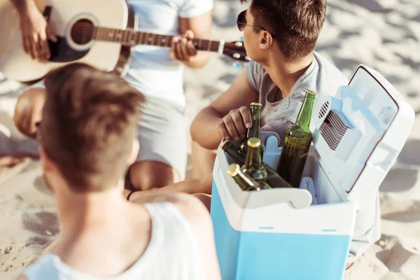 Friends drinking beer at beach — Stock Photo