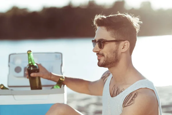 Homme buvant de la bière à la plage — Photo de stock