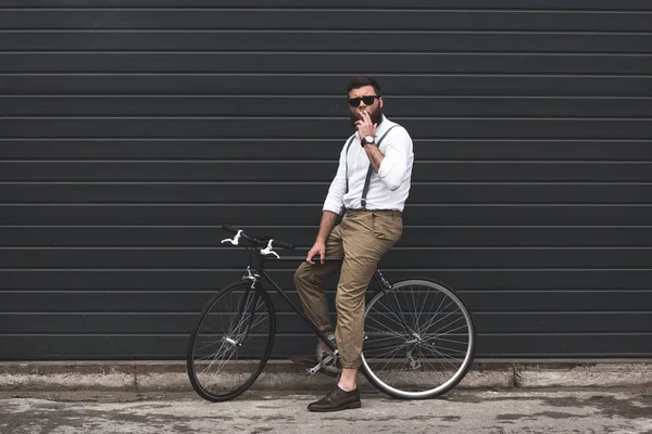 Homme en lunettes de soleil assis sur le vélo — Photo de stock