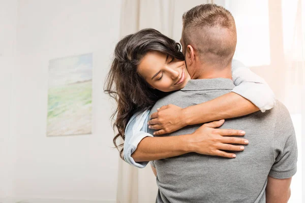 Feliz casal abraçando em casa — Fotografia de Stock