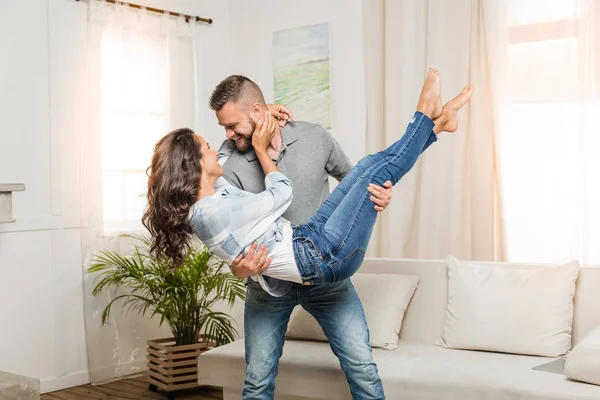 Hombre sosteniendo a mujer en sus brazos - foto de stock