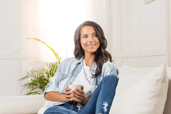 Mujer joven sosteniendo taza - foto de stock